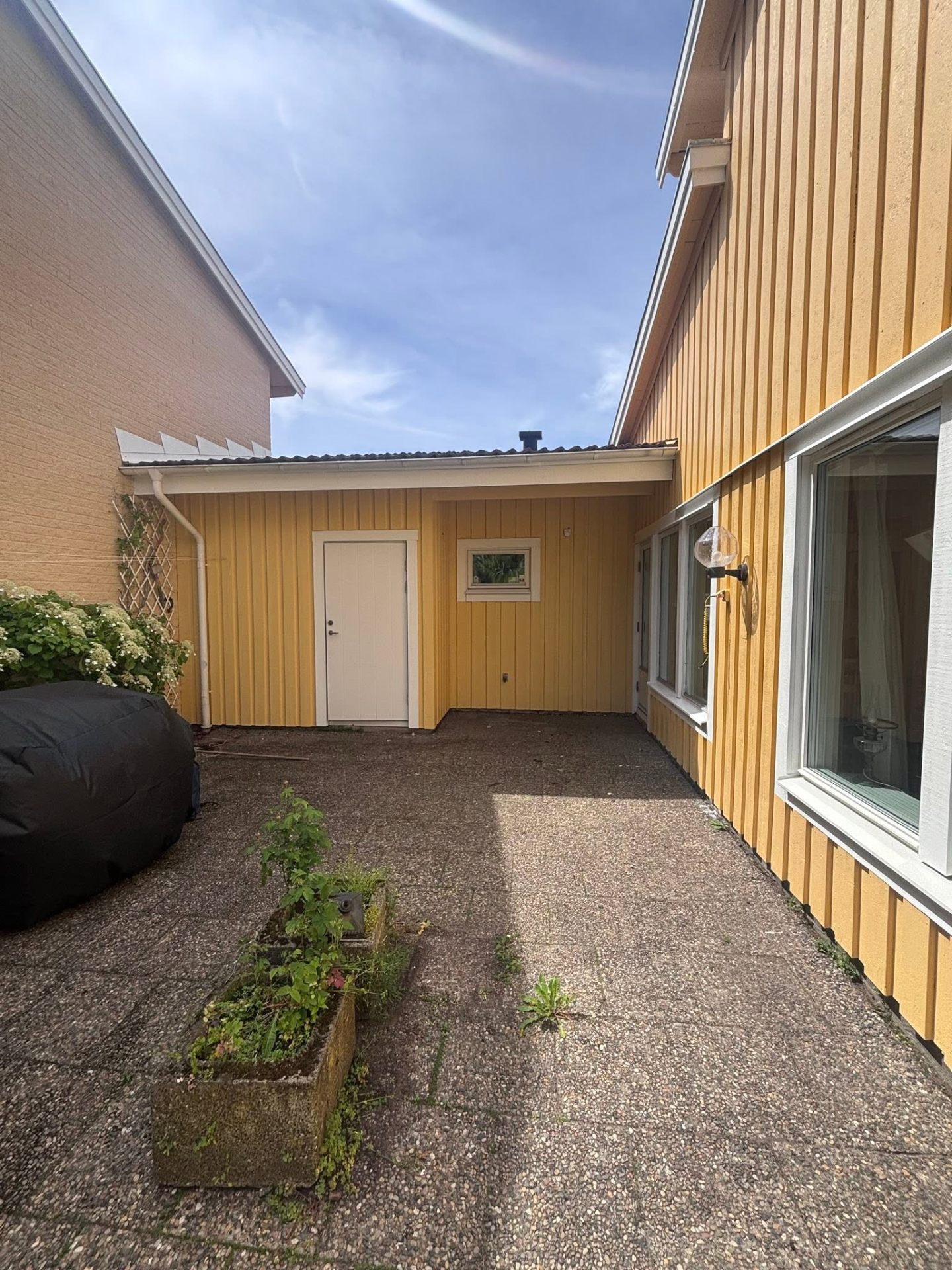 Innergård med nymålad gul fasad och vit dörr